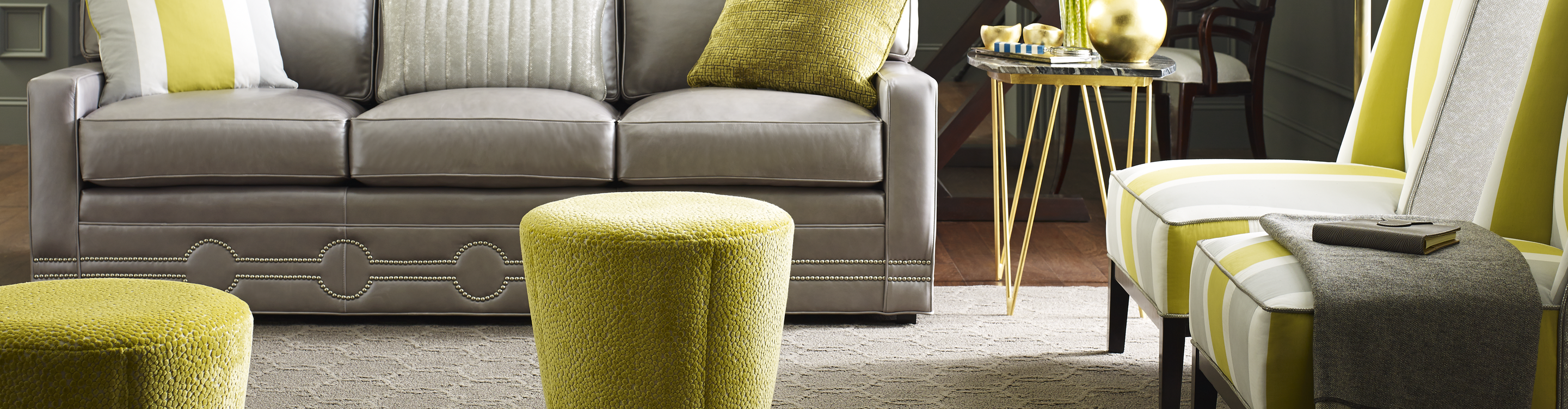 neutral patterned carpet area rug in gray living room with green accent pillows